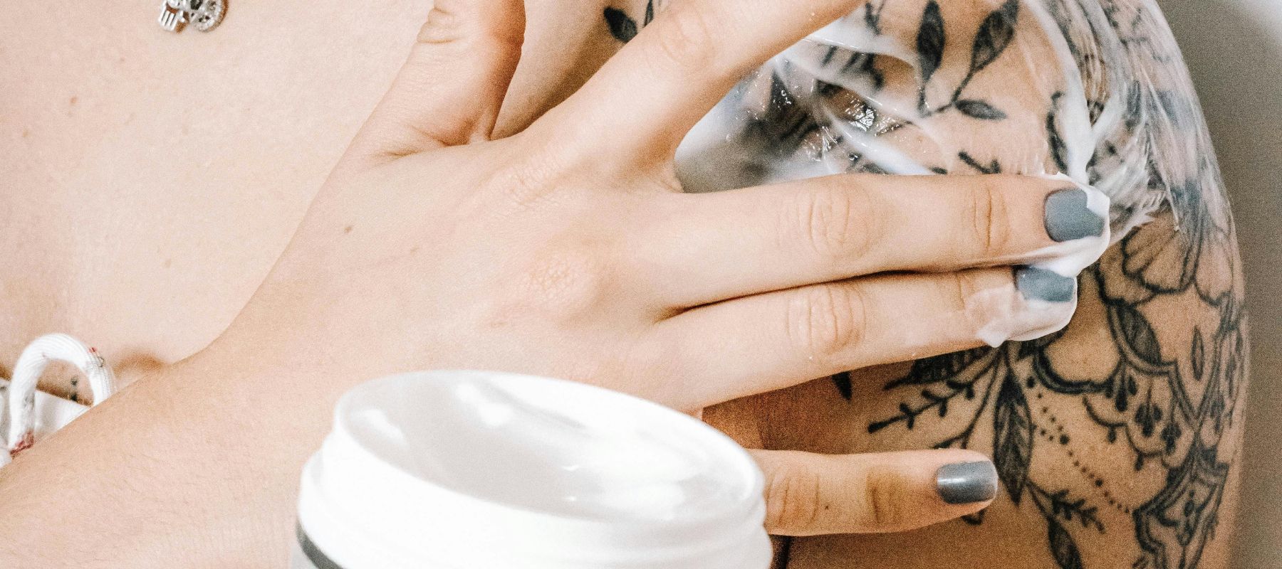 woman using coco butter on a fresh tattoo